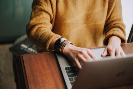 Editorial image of hands typing on laptop keyboard
